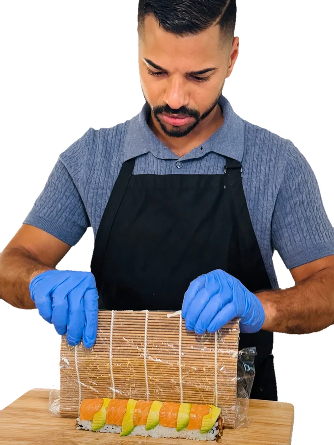 James Poindexter in an apron, rolling sushi in his kitchen